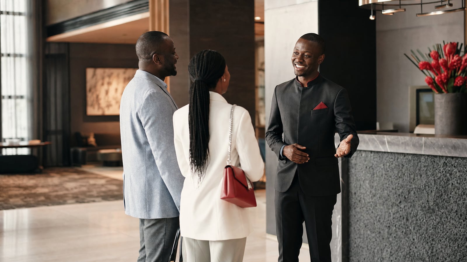 African hotel manager welcoming guests in an upscale hotel lobby