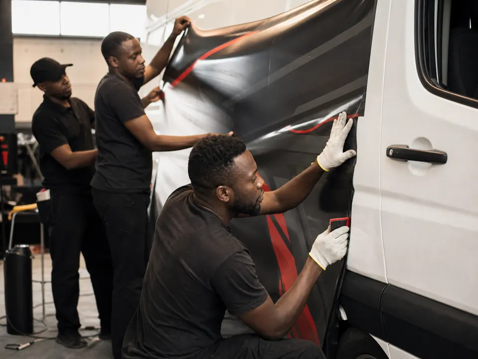 African production specialists applying vehicle branding